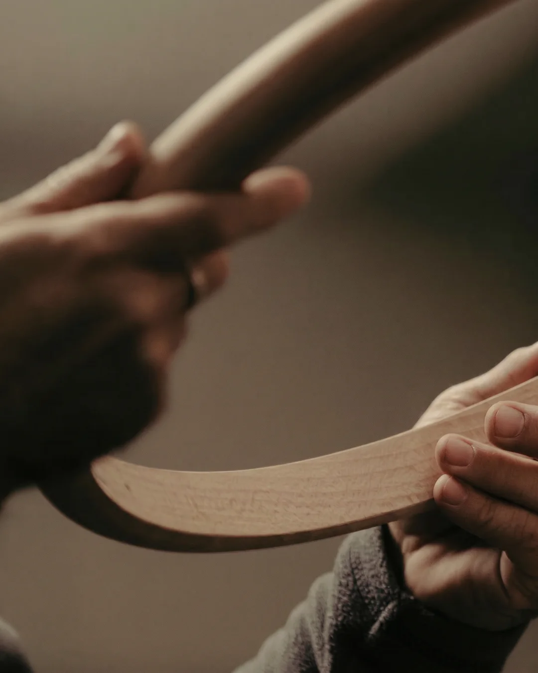 Hands holding the actual carved wood profiles, approved in hand before fabrication